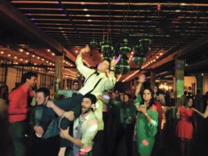 Party Rental FAQ is a compiled list of questions and answers you should read before selecting your entertainment group. A man is carried on shoulders during a wedding reception.