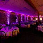 Celebrity Productions is a West Michigan based party productions company. Purple wall lights illuminate a wedding reception venue.