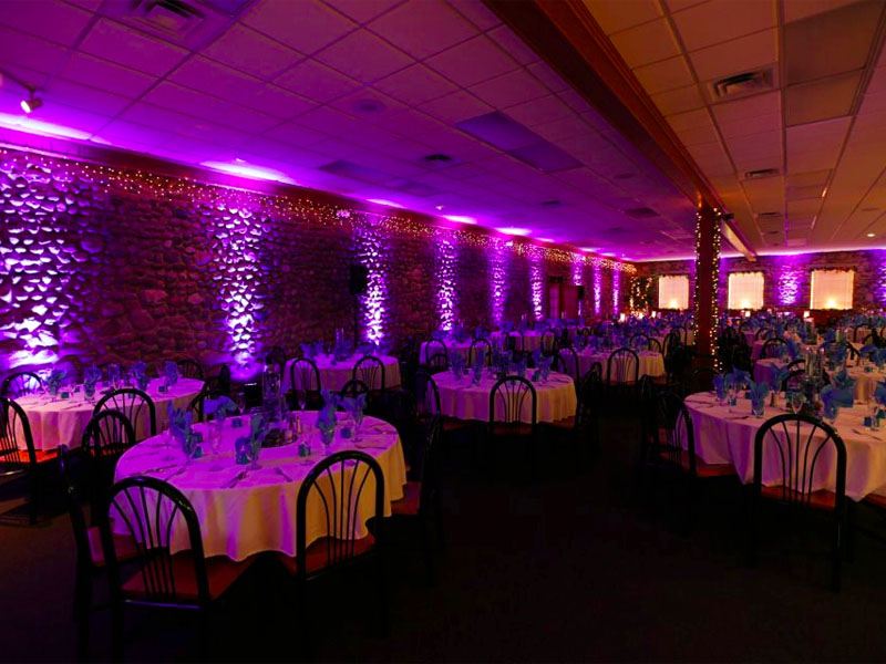 Celebrity Productions is a West Michigan based party productions company. Purple wall lights illuminate a wedding reception venue.